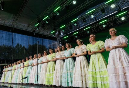 Na scenie Artyści Chóru w kostiumach stylowych z końca XIX wieku