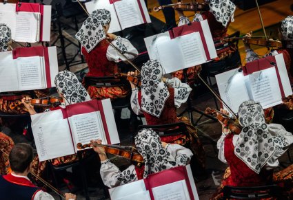 Widok z góry na Artystów Orkiestry w kostiumach wilanowskich, grających na instrumentach smyczkowych