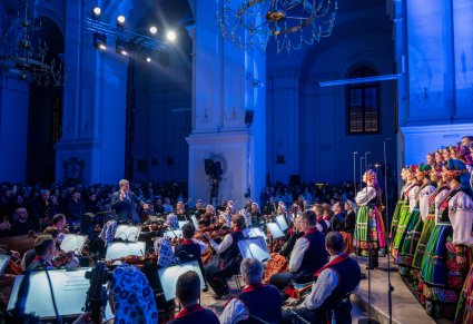 Widok na Orkiestrę w kostiumach wilanowskich z Dyrygentem, Dyrektorem zespołu "Mazowsze" i Chór w kostiumach łowickich przed gośćmi koncertu kolęd i pastorałek
