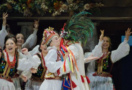 Zbliżenie na całującą się Parę Młodą a w tle widoczna część Artystów w kostiumach krakowskich