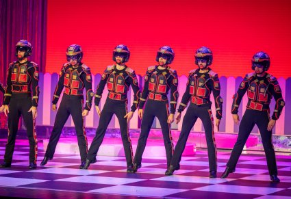 Sześć postaci kwadratów stojących w rzędzie, ubranych w charakterystyczny czarny kostium oraz kask