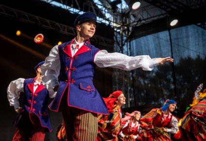Artyści na scenie w choreografii tanecznej w kostiumach sieradzkich
