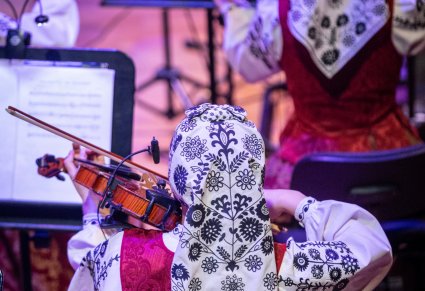 Ujęcie od tyłu Muzyczek  w kostiumach wilanowskich grających na instrumentach smyczkowych