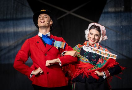 Para uśmiechniętych Artystów z chóru na scenie w kostiumach lubuskich