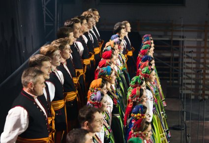 Widok boczny na Artystów Chóru w kostiumach łowickich