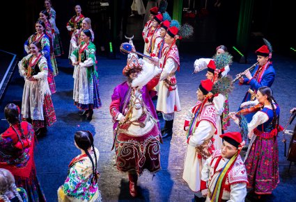 Grupa Artystów zespołu "Mazowsze" w kostiumach krakowskich wraz z Laikonikiem na scenie