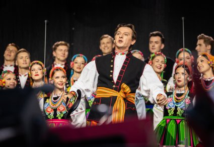 Na pierwszym planie solista chóru podczas wykonywania pieśni "Furman" ,w tle reszta chóru