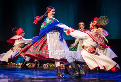 Artyści na scenie wykonujący choreografię taneczną w kostiumach krakowskich