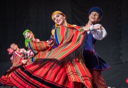 Trzy pary Artystów na scenie w kostiumach sieradzkich w trakcie wykonywania choreografii tanecznej