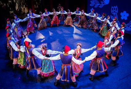 Artyści zespołu "Mazowsze" w kostiumach krakowskich podczas wykonywania choreografii tanecznej