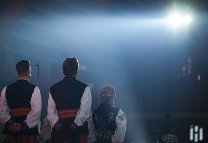 Artyści Chóru w kostiumach łowickich zwróceni w stronę Publiczności