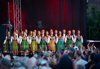Na scenie widok na część Artystów Chóru w kostiumach łowickich