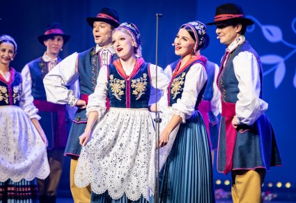 Zbliżenie na artystów w kostiumach kaszubskich wykonujących utwór