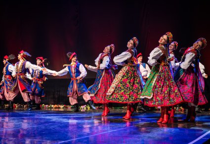 Artyści na scenie wykonujący choreografię taneczną w kostiumach krakowskich