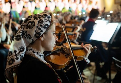 Zbliżenie na Muzyczkę w kostiumie wilanowskim grającą na instrumencie smyczkowym