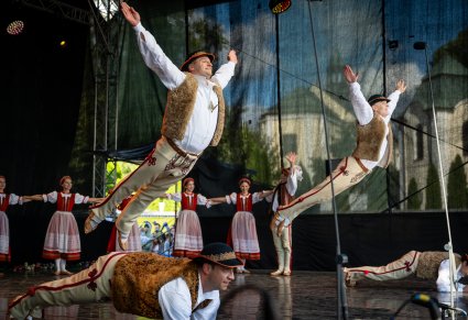 Artyści na scenie w kostiumach jurgowskich wykonujący  choreografię taneczną