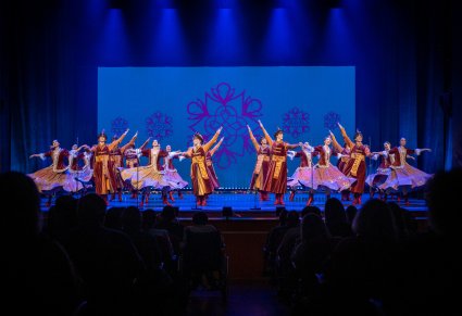 Grupa tancerzy w kontuszach na scenie wykonujący układ taneczny