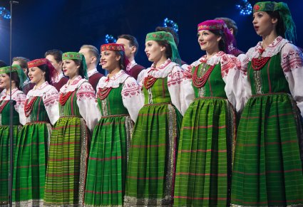 Grupa Chórzystów w kostiumach kurpiowskich w trakcie śpiewu