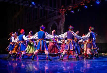 Artyści na scenie wykonujący choreografię taneczną w kostiumach krakowskich