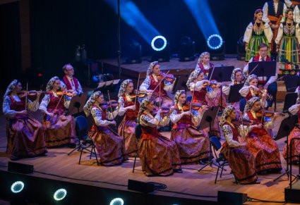 Widok na część Orkiestry smyczkowej w kostiumach wilanowskich, w tle część Artystów Chóru w kostiumach łowickich