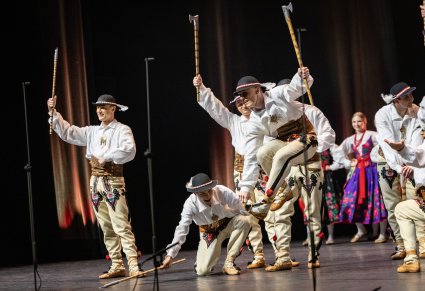 Na scenie Artyści w kostiumach podhalańskich w trakcie wykonywania choreografii tanecznej