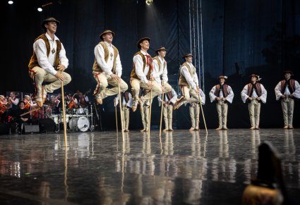 Na scenie grupa Artystów w kostiumach jurgowskich podczas wykonywania choreografii tanecznej