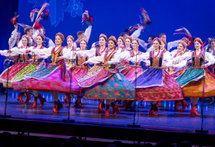 Na scenie Artystki w kostiumach krakowskich wykonujące choreografię taneczną