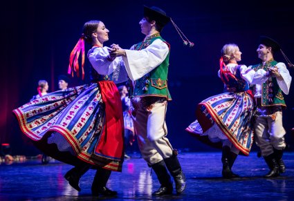 Zbliżenie na parę taneczną w kostiumach spiskich podczas obrotów