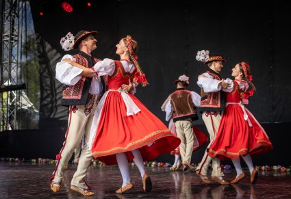 Trzy pary Artystów na scenie w kostiumach jurgowskich wykonujący choreografię taneczną