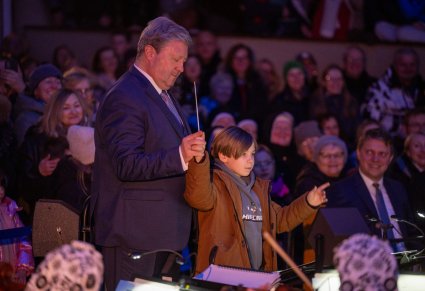 Dyrektor zespołu "Mazowsze" w trakcie wspólnego dyrygowania z młodym mieszkańcem Grodziska Mazowieckiego