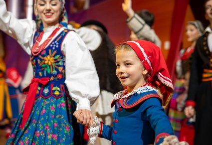 Zbliżenie na Artystkę i Małą dziewczynkę w kostiumach ludowych w trakcie wchodzenia na scenę