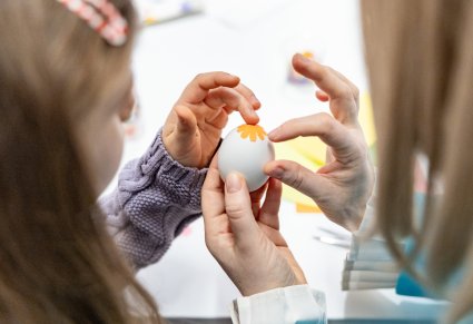 Wspólne oklejanie jajka przez uczestniczki warsztatów rękodzielniczych w Pałacu w Karolinie