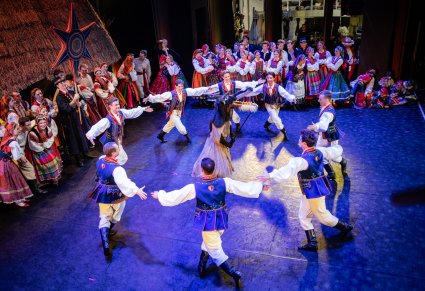 Na scenie Artyści w kostiumach ludowych podczas wykonywania choreografii grupowej