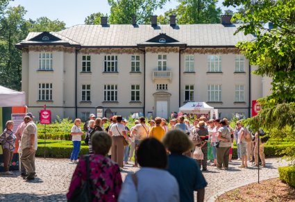 Na pierwszym planie Goście IX Pikniku Rodzinnego z Zespołem "Mazowsze" w tle Pałac w "Karolinie"