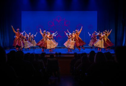 Grupa tancerzy w kontuszach na scenie wykonujący układ taneczny