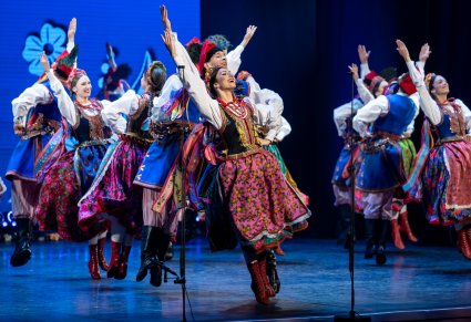 Artyści w kostiumach krakowskich podczas wykonywania choreografii tanecznej ba scenie