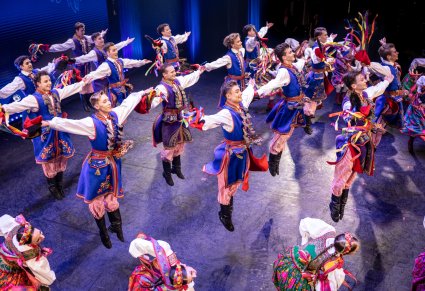 Grupa Artystów w kostiumach krakowskich podczas wykonywania choreografii tanecznej