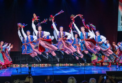 Artyści na scenie wykonujący choreografię taneczną w kostiumach krakowskich