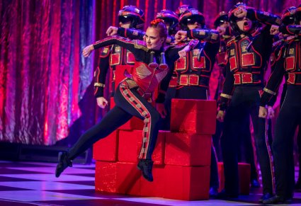 Postaci kwadratów we wspólnej scenie. Kwadraty mają kolor czerwony i noszą kaski, jest jedna postać damska tu na pierwszym planie