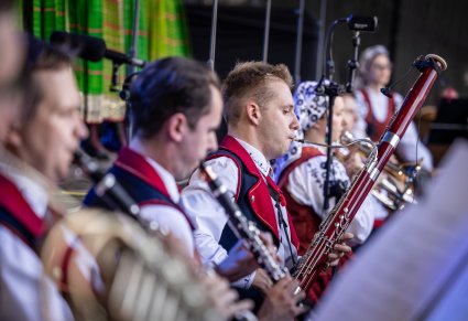 Zbliżenie na Artystów Orkiestry w kostiumach wilanowskich podczas gry na instrumentach dętych