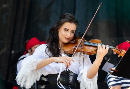 Zbliżenie na Artystkę Orkiestry w kostiumie pirackim, grającą na skrzypcach