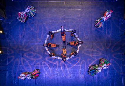 Zdjęcie z góry na scenę z tancerzami w kostiumach łowickich