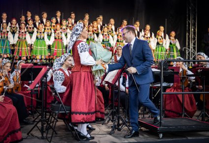 Na zdjęciu widoczny dyrygent przekazujący kwiaty i podziękowania koncertmistrzyni