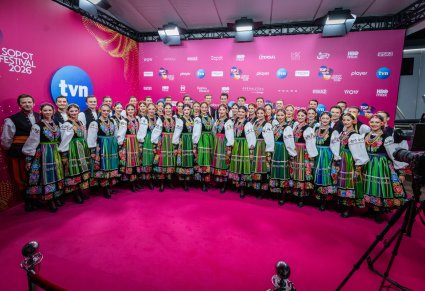 Chór w kostiumach łowickich podczas zdjęcia na ściance festiwalowej