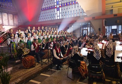 Boczna perspektywa widoku na ołtarz na którym znajdują się Artyści Orkiestry w kostiumach wilanowskich oraz Artyści Chóru w kostiumach łowickich