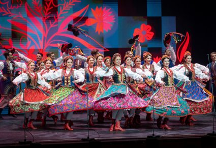 Tancerki w kostiumach krakowskich w obrotach na scenie