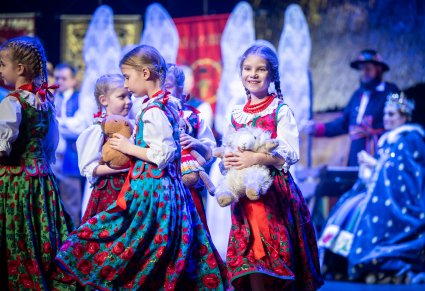 Zblizenie na przedszkolaki w kostiumach ludowych, trzymające pluszowe maskotki w dłoniach