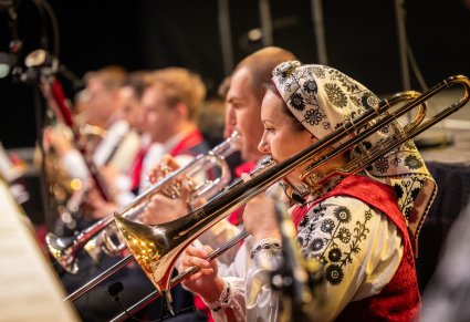 Muzycy orkiestry w kostiumach wilanowskich, grający na instrumentach dętych