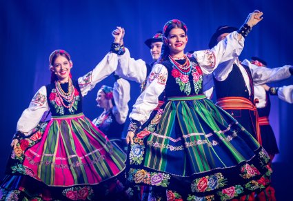 Zbliżenie na artystki w kostiumach łowickich podczas występu na scenie