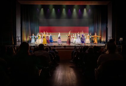 Widok przez publiczność na scenę na której są Artyści baletu w kontusza wykonujący choreografię taneczną